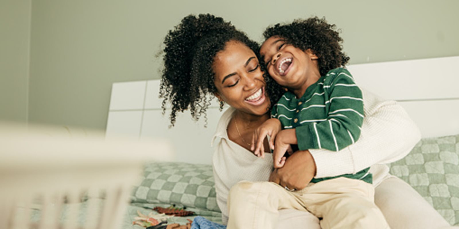 Mother and small child hugging and laughing